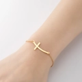 Elegant gold minimalist curved cross bracelet on female wrist with polished finish - 341-Curved Cross