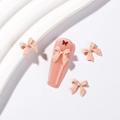 Nail art nœud rose mat avec papillon scintillant sur de faux ongles longs cercueil - Nude