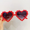 Primer plano de gafas de sol infantiles de corazón con montura roja ondulada y lentes lila - Rojo