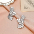 Modern silver irregular flower petal earrings on a pink satin background for women - Silver