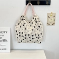 Close-up of cream canvas tote bag with cat and dog prints and pink woven handles - Black Cat & Dog