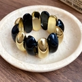 Detail of minimalist elastic bracelet with alternating black resin and gold metal beads - Black