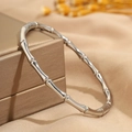 Primo piano dettagliato di un bracciale in acciaio inossidabile argento stile bambù - Argento