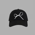 Close-up of white bow embroidery detail on a premium black cotton baseball cap - Bow Embroidered Baseball Cap Style / Black
