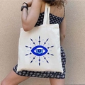 Borsa tote in tela beige con stampa Evil Eye greco mostrata indossata da modella - STD1804-D Occhio con Bagliore Stellare