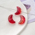 Close-up of three vibrant red crescent-shaped glass tulip beads on white textured plate - Bright Red Translucent Crescent (11# 10Pcs Price)