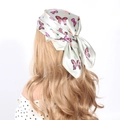 Detail of light green silk square scarf with colorful butterfly prints tied as a head bow - Light Green