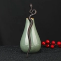 Detail of snake-shaped dark sandalwood hair pin leaning on a celadon vase with red berries - Snake Shape Ebony Wood (F2023727)