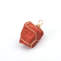 Macro view of a handmade wire-wrapped irregular red raw crystal stone pendant - Red Jasper