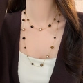 Détail du collier étagé avec œil de tigre et perles dorées porté sur un gilet marron - 78# Sautoir Perles Mixtes Géométrique Café