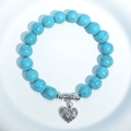 Sky blue turquoise bead bracelet with a silver hollow heart charm on a white tray - Blue Turquoise Heart Charm