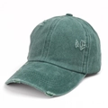 Detailed close-up of distressed washed cotton texture on a green baseball cap - Green
