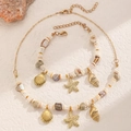 Set gioielli bohémien con ciondoli a stella marina e conchiglia in oro e perle - Set di collana e bracciale con perline dorate, stella marina e conchiglia