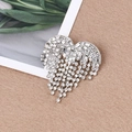 Primo piano di una spilla a cuore d'argento con nappe di strass scintillanti su feltro - Cuore Argento con Frangia (XD8978-2)
