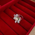 Macro detail of a floral ring with silver petals and pavé diamonds in a red velvet box - Ring-Silver (Open Daisy Ring)