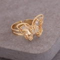 Macro shot of gold butterfly ring with crystals on a textured stone surface - Adjustable Open / White