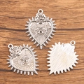 Silver Halloween heart charms with embossed rose and eye motifs on wood background - 28C3-7 Rose Eye Heart