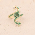 Golden snake ring with green enamel, white zircons and gemstone on a beige stone surface - Snake Style (1#)