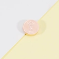 Detalle macro del colgante cilíndrico de oro rosa con una figura grabada finamente - Oro rosa