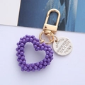 Dettaglio portachiavi a cuore con perline viola, anello dorato e targhetta incisa - Confezione in busta singola OPP / Cuore di Perla Viola