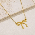 Detail shot of a liquid gold bow pendant necklace on a natural stone textured background - Liquid Metal Bow Knot (NKS-002_05)