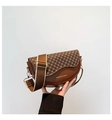 Detalle de bolso de silla marrón con estampado geométrico y correa ancha de cuero - Marrón Trébol
