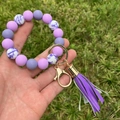 Dettaglio del bracciale con perline di silicone viola e ciondolo nappa con portachiavi - Combinazione Motivo Cineseria Viola (A4)