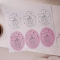 Detailed view of pink and white oval Happy Birthday stickers for gift sealing and packaging - Style A Cat Cake (6 Pcs/Sheet)