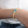 Elegant gold titanium cuff bracelet with turquoise evil eye charms worn by a model - Gold Color (Z288)