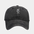 Close-up of dandelion and faith embroidery on a black washed denim baseball cap - Black