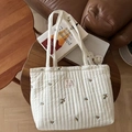 Dettaglio della borsa tote trapuntata color crema con ricami floreali e toppa in tessuto - Ricamo a Piccoli Fiori a Righe