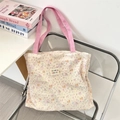 Detail of quilted canvas tote bag with floral puppy prints and pink handles on a chair - Colorful Star Puppy