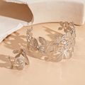 Detail of silver floral cutout bangle and ring set on minimalist stone background - Silver Four-petal Flower (2-piece set)