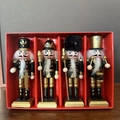 Detail of four black and gold wooden nutcracker ornaments in a red gift display box - Black and Gold Nutcracker 4-Piece Set