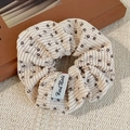 Chouchou en velours côtelé fleuri beige avec étiquette Hand Made sur fond texturé - Floral beige en velours côtelé / Poche zippée