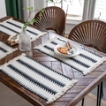 Bohemian woven placemat with black geometric patterns and fringes on wooden table - Forest Black Tree