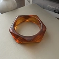 Detail view of a hexagonal amber resin bangle with unique geometric marble textures - Amber