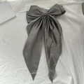 Elegant large grey satin bow hair clip with long ribbons on a textured white background - Dark Gray