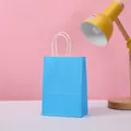Sky blue kraft paper gift bag with white twisted rope handles on white tabletop - Light Blue / 21*15*8