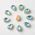 Macro detail of teardrop blue rhinestones in gold claw settings for DIY sewing - 10x14mm / Aqua Blue AB