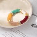 Detail of colorful acrylic tube bracelet with marble texture and gold metallic beads - Deep Multicolor