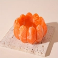 Detail of orange marble acrylic oval links on a textured stone display tray - Orange