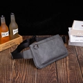 Minimalist matte grey sling bag with adjustable strap and front zip pocket on a wooden desk - Gray