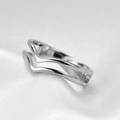 Detail of interlocking V-shaped silver ring on white silk texture with macro focus - US 5 / Steel