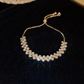 Detail of gold double-row zircon bracelet with adjustable slider clasp on black velvet - 21# Bracelet - Gold