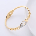 Dettaglio del bracciale in metallo dorato con pavé di strass e design a cerchio cavo - Oro