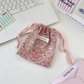 Macro view of pink floral drawstring storage bag with premium fabric texture and cord - Strawberry Bird