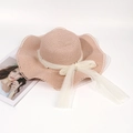 Detail of straw hat featuring a mesh bow with elegant white pearls and wavy brim - Pink