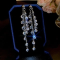 Dettaglio di orecchini a nappa d'argento con zirconi in una scatola di velluto blu - Stile Nappa Lunga / Argento