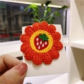 Handmade orange crochet flower hair clip with a strawberry motif on a display card - Orange Flower With Strawberry